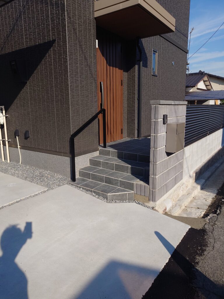 新築エクステリアの玄関アプローチに設置したブラックの手摺。段差のある動線でも安全に昇降できるシンプルなデザイン