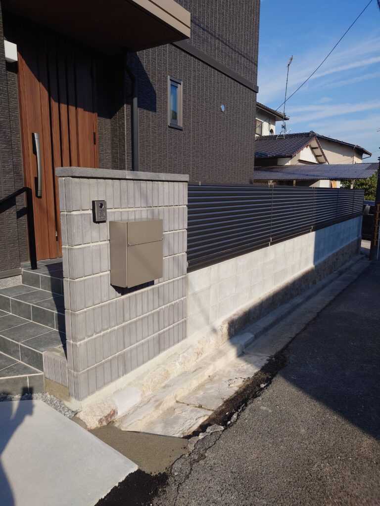 新築住宅の玄関前にポストとインターホンを集約した門柱と目隠しフェンス。動線を邪魔せずプライベート空間を確保した外構